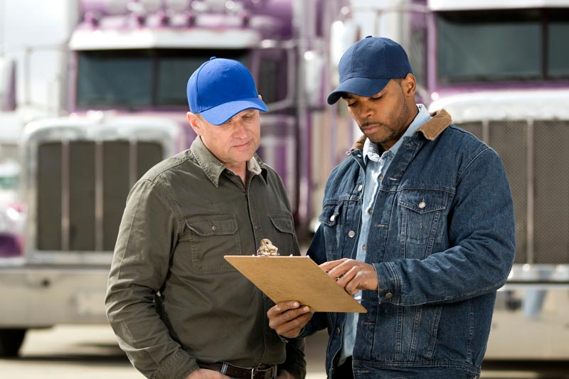 Truck Driver and Dispatcher discussing compliance documents